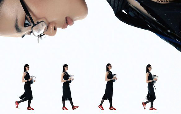 A woman in glasses looking down at four models.
